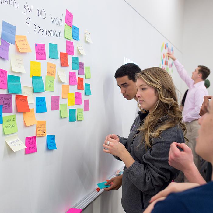 Students brainstorm using brightly colored sticky notes