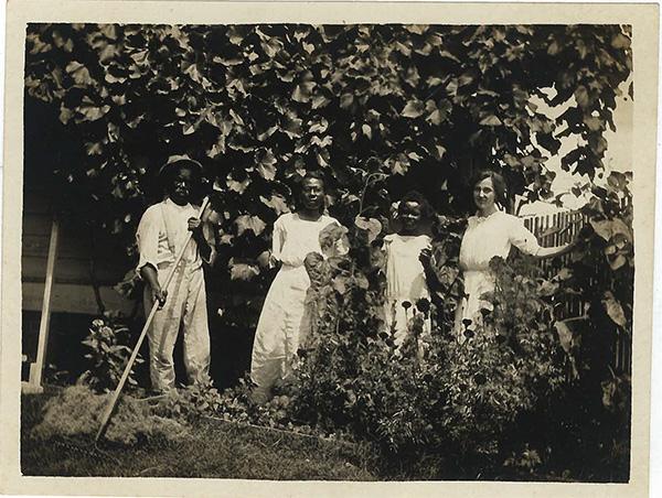 一个白人和三个黑人在一棵树前摆姿势